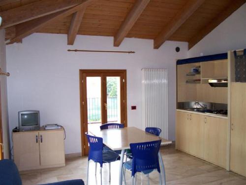 eine Küche mit einem Holztisch und blauen Stühlen in der Unterkunft RESIDENCE LA VECCHIA REGGIO in Reggio nell'Emilia