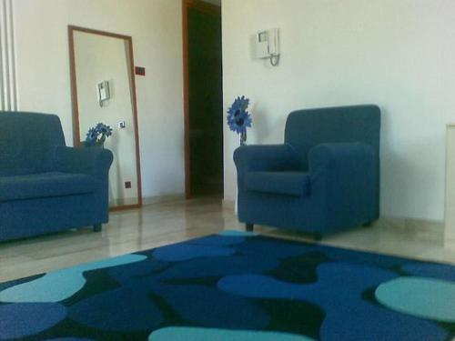a room with two blue chairs and a blue rug at RESIDENCE LA VECCHIA REGGIO in Reggio Emilia