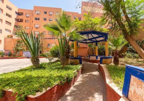 un parc avec des palmiers en face d'un bâtiment dans l'établissement Adorable 2-bedrooms flat in Gueliz, à Marrakech