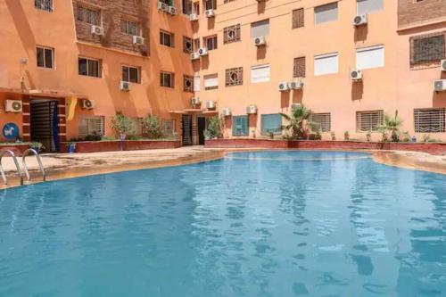 une piscine en face d'un bâtiment dans l'établissement Adorable 2-bedrooms flat in Gueliz, à Marrakech
