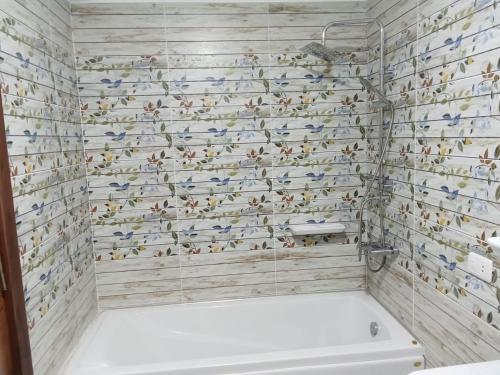 a bathroom with a shower with birds on the wall at The perfect stay in Cairo al muhandesin Nile luxury apartment in Cairo