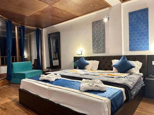 a bedroom with a large bed and a blue chair at Hotel Norling SK Groups in Pelling