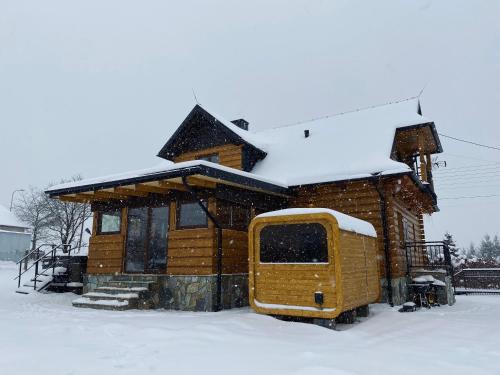 a log cabin with snow on top of it at Apartamenty Arkadia Jaworzynka - Zapasieki in Jaworzynka