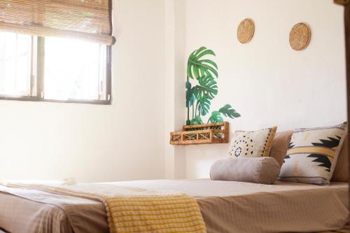 a bedroom with a bed with a yellow blanket on it at Marshmallow Homestay in Ahangama