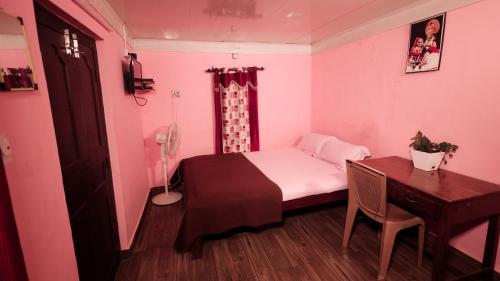 um pequeno quarto com uma cama e uma secretária em CAFFEE ISLAND FARM VILLA em Kaniyāmbetta