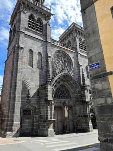 a large stone building with an archway in front at LA HUPPE - Bain Balnéo - Riom centre - 3 étoiles in Riom