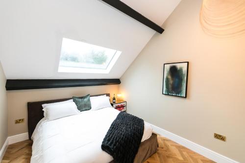 una camera con un letto bianco e una finestra di The Sky Lodge & Penthouse Apartments at Hillthorpe Manor by Maison Parfaite - Wentbridge a East Hardwick