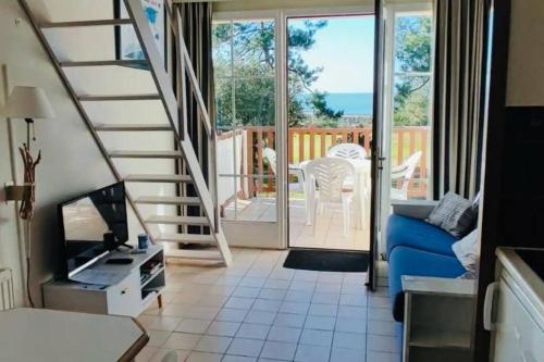 een woonkamer met een blauwe bank en een balkon bij "LA BELLE VUE" Appartement 5 personnes en duplex, jolie vue mer, accès parc aquatique gratuit in Talmont