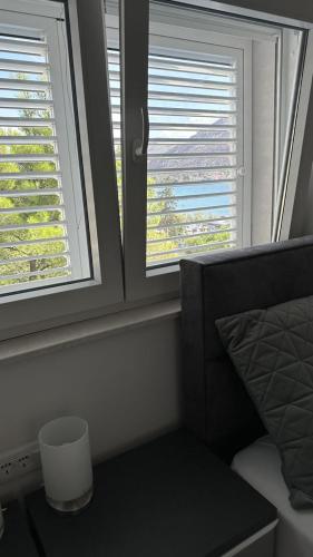 a bedroom with two windows and a bed and a table at Arte Oliva in Grebaštica