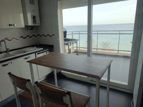 a kitchen with a table and a view of the ocean at Appartement pied dans l'eau avec vue mer in Sousse