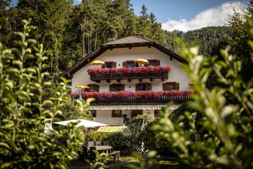 a building with flowers on the side of it at Residence Obermoarhof - Family Apartments with Pool & Playground in Vandoies