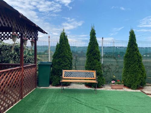 un banc dans un jardin avec une clôture et des arbres dans l'établissement Sunset Villa, à Costinesti