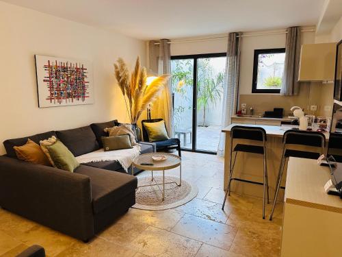 un salon avec un canapé et une cuisine dans l'établissement Appartements 3 étoiles terrasse ou patio intra-muros, à Aigues-Mortes