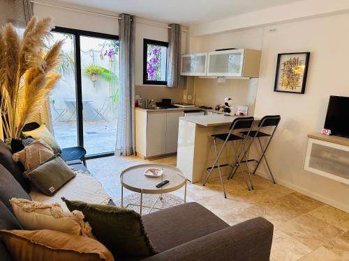Il comprend un salon avec un canapé et une cuisine. dans l'établissement Appartements 3 étoiles terrasse ou patio intra-muros, à Aigues-Mortes