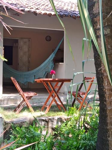 a patio with a hammock and a table and chairs at Stay Cool Pipa in Pipa