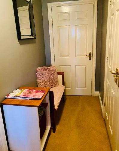 a room with a door and a chair and a table at Modern ground floor apartment with free parking very near centre in Ripon