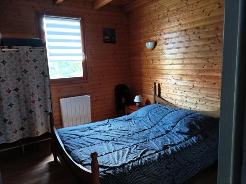 - une chambre avec un lit et un mur en bois dans l'établissement Chaleureux gîte des brocards aux pieds des sapins 3 étoiles, à Allarmont
