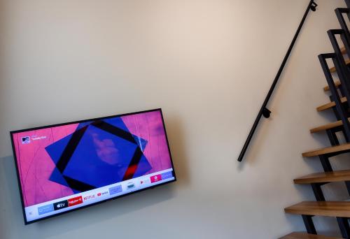 een flatscreen-tv aan een muur bij Bridge Apartment in Klaipėda