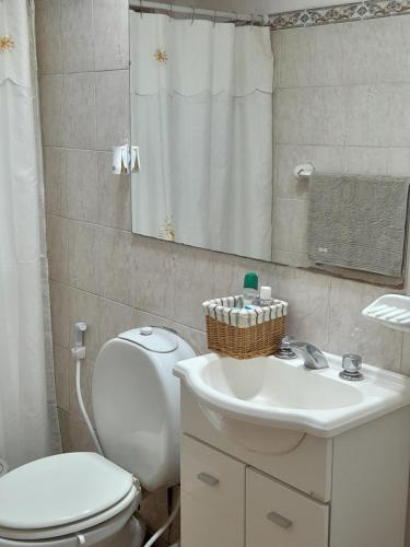 y baño con aseo blanco y lavamanos. en Villa Lainez en Villa Mercedes