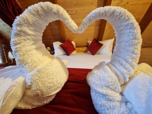 a bed with white sheets and a heart made out at Casuta Armonia in Moisei