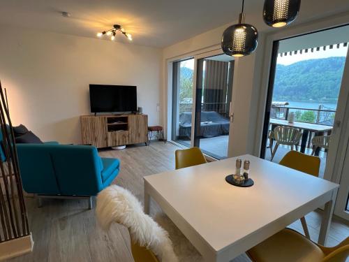 sala de estar con mesa y TV en Ferienwohnung mit Seeblick - Ossiacher See Gerlitzen en Sattendorf