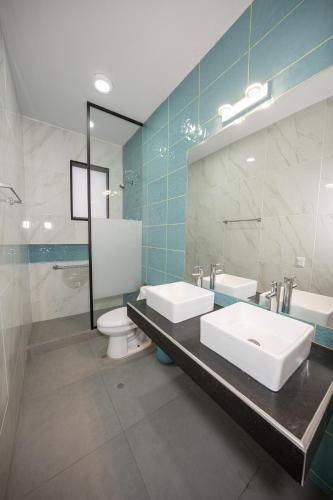 a bathroom with two sinks and a toilet and a mirror at Mar y campo Casa Huarca in La Isla