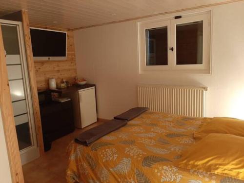 Un dormitorio con una cama grande y una cocina. en Chambre Cocooning, en Viuz-en-Sallaz