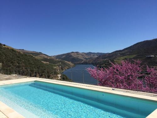 a swimming pool with a view of a lake and mountains at Quinta Da Marka in Covas do Douro