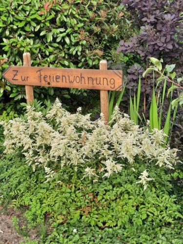 um sinal no meio de um jardim em Ferienwohnung van den Berg em Rees