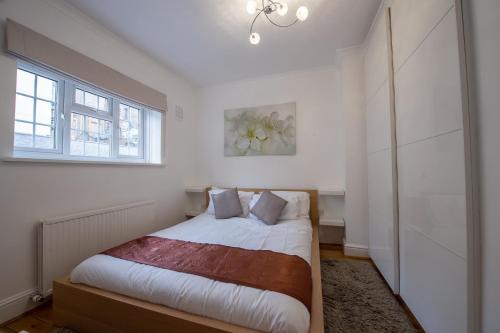um quarto com uma cama e uma janela em Mayfair Town House em Londres