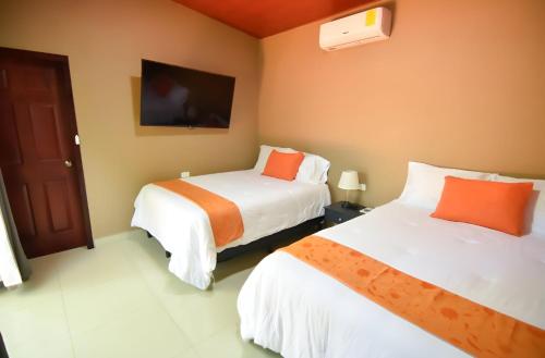 um quarto de hotel com duas camas e uma televisão em Cabaña Villa de Ada em Gracias