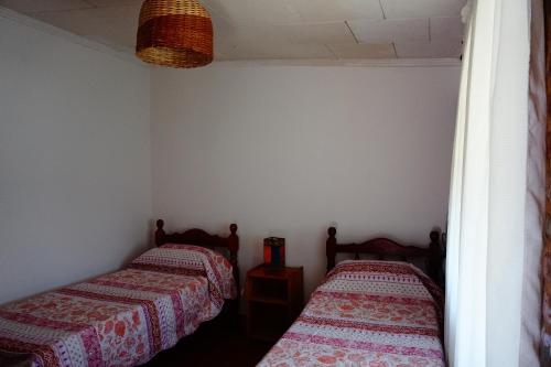 two beds in a small room with at Estrelitzia Hospedaje in Reyes