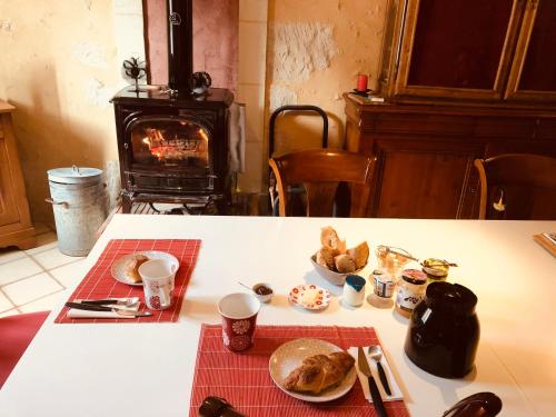 una mesa con un plato de comida y una estufa en Chambres d'hôtes Le 42 en Nogent-le-Rotrou