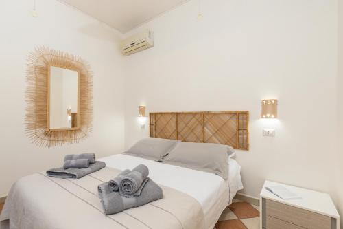 - une chambre avec un lit blanc et des serviettes dans l'établissement Maestrale a pochi passi dal mare, à Santa Maria Navarrese