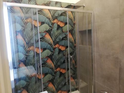 a shower curtain with a mural of leaves at Le Case di Rita in Naples