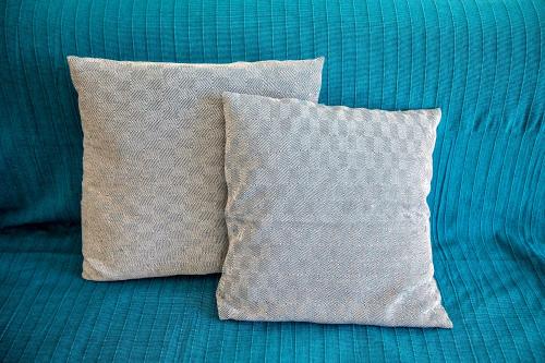 a pillow sitting on top of a blue bed at Seaside Serenade 1, suite in Ermoupoli