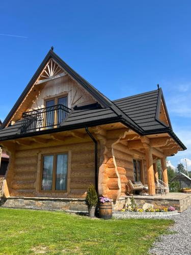 a log cabin with a black roof at Uroczy drewniany domek - Domki pod Brzegiem in Zakopane