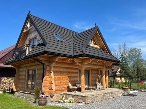 uma cabana de madeira com um telhado preto em Uroczy drewniany domek - Domki pod Brzegiem em Zakopane