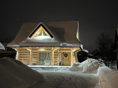 a small house covered in snow at night at Uroczy drewniany domek - Domki pod Brzegiem in Zakopane