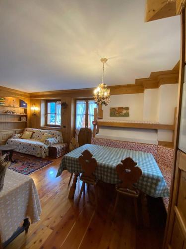 a living room with a table and a bed at Chalet Panorama Dolomiti in San Vito di Cadore