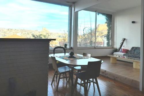 une salle à manger avec une table et des chaises et une grande fenêtre dans l'établissement Appartement vue imprenable, au Puy-en-Velay