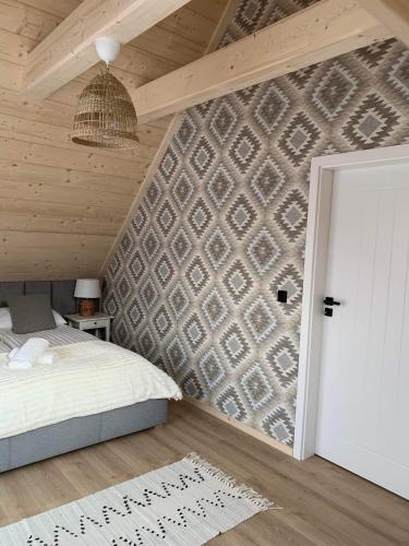 a bedroom with a brick wall with a bed and a door at Uroczy drewniany domek - Domki pod Brzegiem in Zakopane