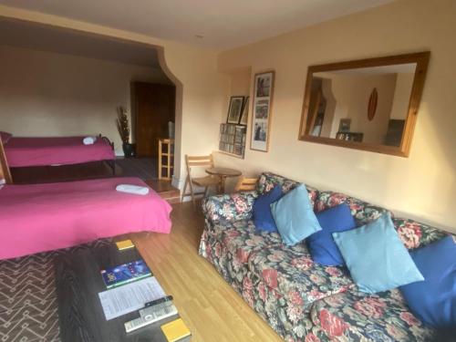 a living room with a couch and a bed at Ground Floor - view of Lighthouse, Garden and Parking in Swansea