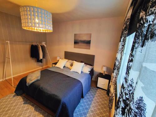 een slaapkamer met een bed en een kroonluchter bij Spacious apartment with balcony and free WiFi in Rovaniemi