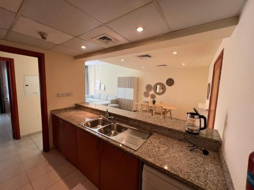 uma cozinha com um lavatório e um espelho grande em Nice Location - 76 m2 em Dubai