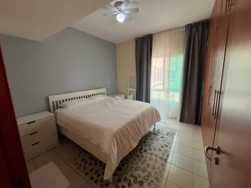 a bedroom with a white bed and a window at Nice Location - 76 m2 in Dubai