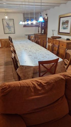 a large table with chairs and a couch in a room at Casa del Lago de Campoo in Orzales