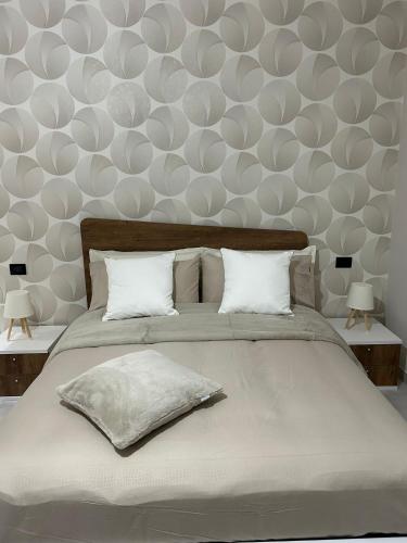 1 dormitorio con 1 cama grande con almohadas blancas en B&B Girasoli, en Scafati