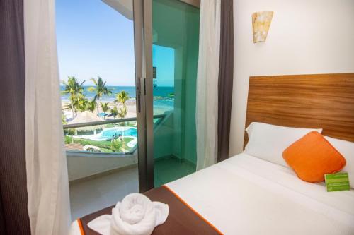 a bedroom with a bed with a view of the beach at Playa Caracol Hotel & Spa in Veracruz