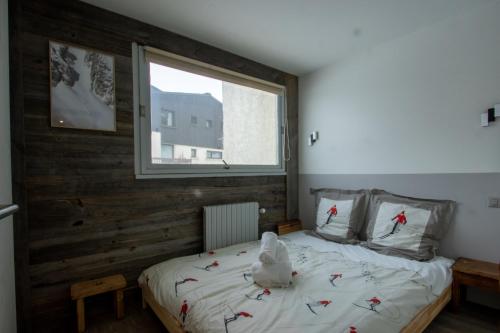 une chambre avec un lit avec un ours en peluche dessus dans l'établissement Tignes - Appartement vue golf, à Tignes